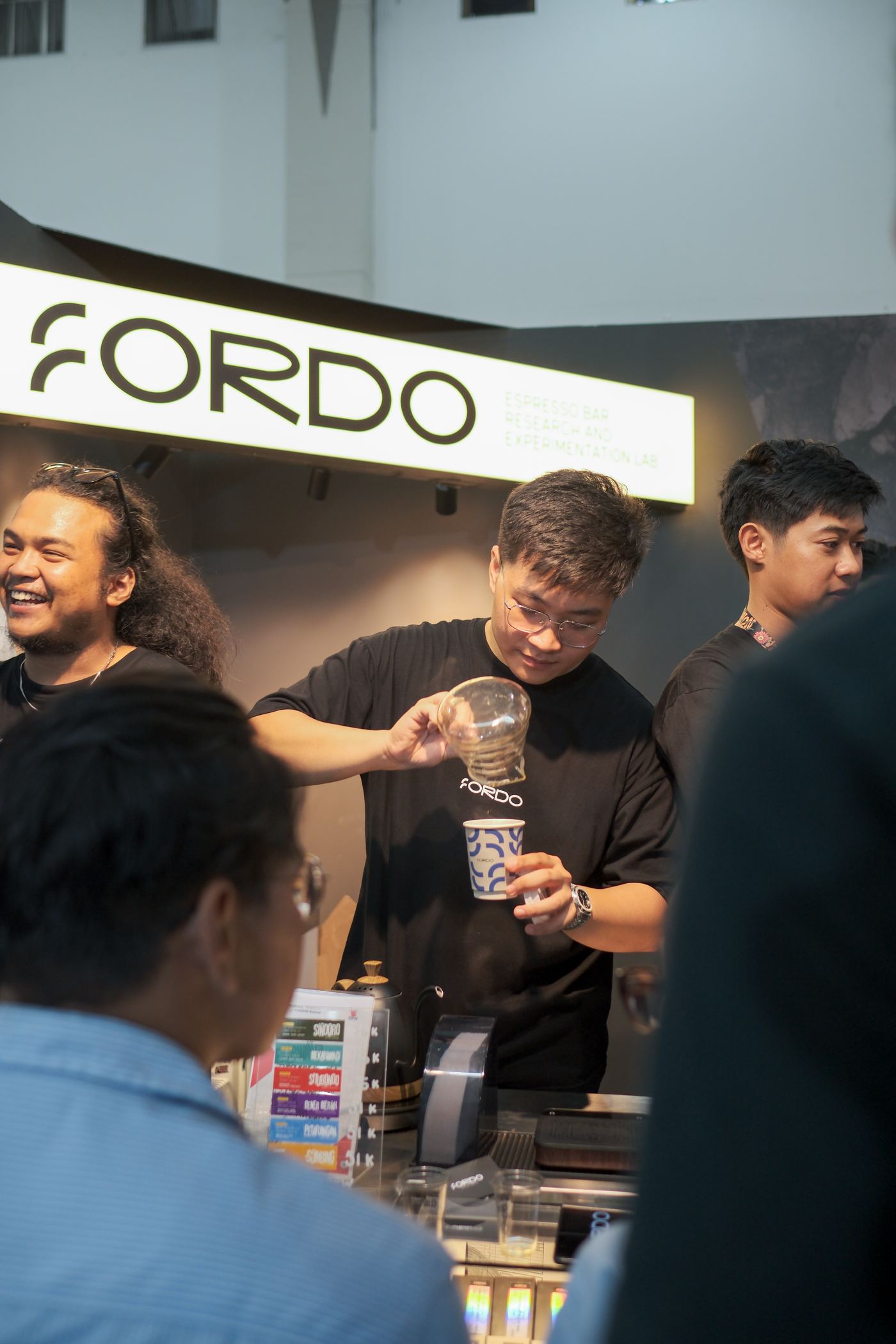 Fordo barista pouring a QA cupping sample at the lab bar